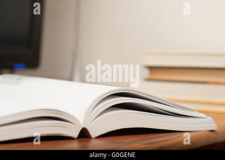 Offenes Buch auf Schreibtisch mit computer Stockfoto