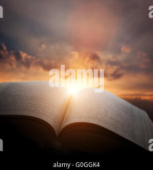 Offene alte Buch, Licht vom Sonnenuntergang Himmel, Himmel. Bildung, Religion-Konzept Stockfoto