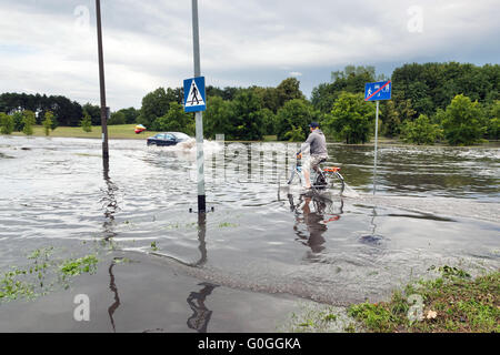 Radsport Mann und Auto versucht, gegen die Flut auf der Straße fahren. Stockfoto