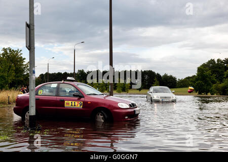 Autos, die versucht, gegen die Flut auf der Straße in Danzig, Polen zu fahren. Stockfoto