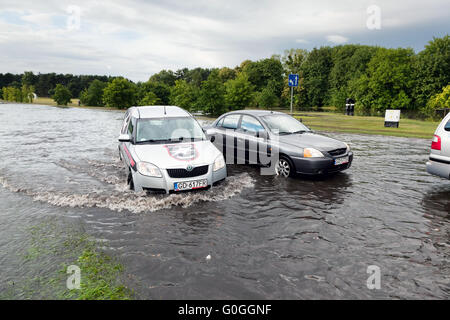 Autos, die versucht, gegen die Flut auf der Straße in Danzig, Polen zu fahren. Stockfoto