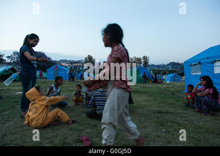 Kinder spielen im Freien ihre zerstörten Häuser in Sankhu Dorf, Nepal. Stockfoto