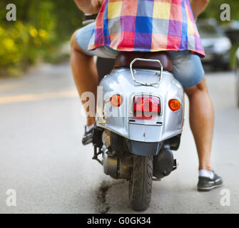Rückansicht des Jünglings Motorroller entlang der Straße Stockfoto