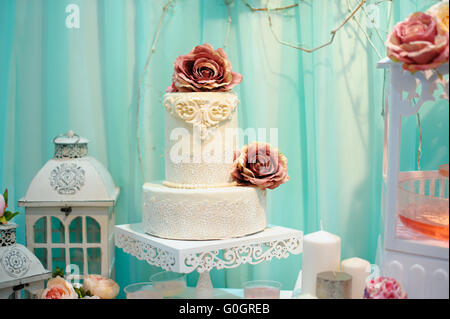 Weiße Hochzeitstorte dekoriert Zucker Muster auf Tisch Stockfoto