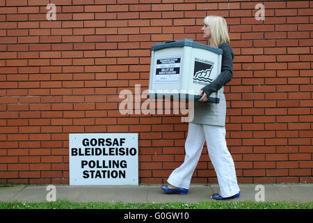 Ein Rat Arbeiter trägt Wahlurnen voller Stimmen bei der Parlamentswahl Auszählung in Barry, South Wales. Stockfoto