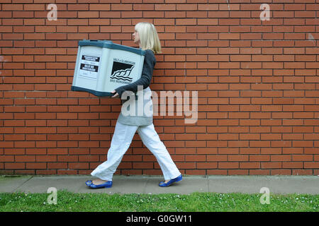 Ein Rat Arbeiter trägt Wahlurnen voller Stimmen bei der Parlamentswahl Auszählung in Barry, South Wales. Stockfoto