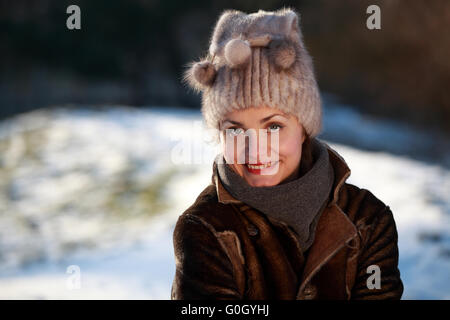 Schöne Mädchen mit Bommel Mütze und Wildleder Jacke im Schnee Stockfoto