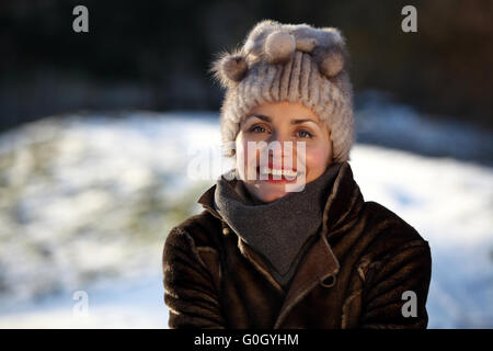 Schöne Mädchen mit Bommel Mütze und Wildleder Jacke im Schnee Stockfoto