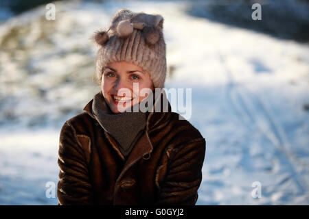 Schöne Mädchen mit Bommel Mütze und Wildleder Jacke im Schnee Stockfoto