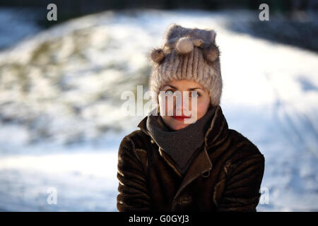 Schöne Mädchen mit Bommel Mütze und Wildleder Jacke im Schnee Stockfoto