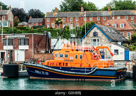 Die strahlend orange Überbau und schwarzen Rumpf alle Wetter Severn Klasse Rettungsboot in Weymouth Lifeboat Station festgemacht Stockfoto