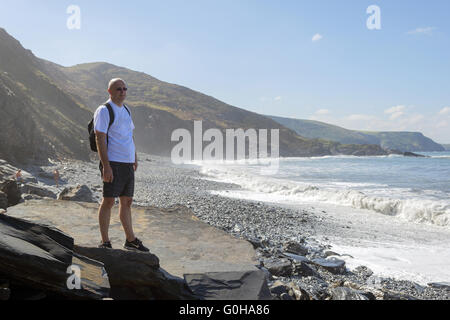 Ein Mann steht auf der North Cornish Küste und blickt auf das Meer. Stockfoto