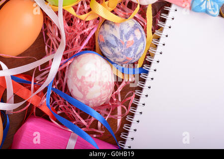 Ostern-Hintergrund mit Eiern, Bändern und Frühlingsdekoration Stockfoto