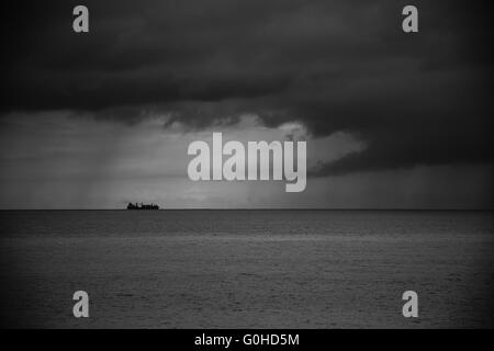 Container schiff am Horizont in Richtung Sturm Stockfoto