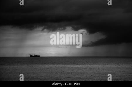 Container schiff am Horizont in Richtung Sturm Stockfoto