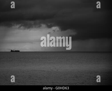 Container schiff am Horizont in Richtung Sturm Stockfoto