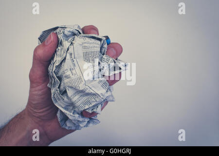 Hand / Faust hält verschraubte Zeitung Stockfoto