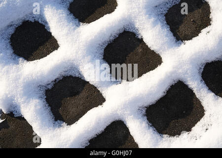 Schnee auf die Fugen der Pflastersteine von einem Fußgängerweg im winter Stockfoto