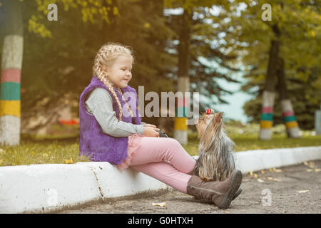 Bild der niedliche kleine Mädchen spielen mit Hund im park Stockfoto