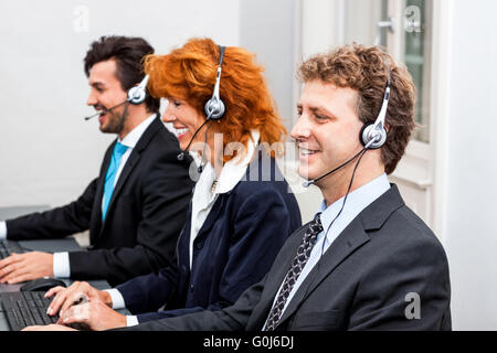 lächelnde Callcenter-Agent mit Kopfhörer-Unterstützung Stockfoto