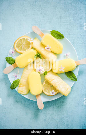 Zitrone und Ananas Eis am Stiel mit frischen Früchten und essbaren Blüten Stockfoto