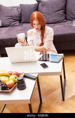 Junge Frau mit Laptop im Wohnzimmer Stockfoto