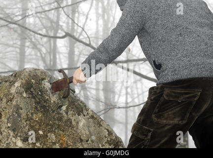 tapferer Ritter anonyme entfernt das magische Schwert Excalibur in den Stein Stockfoto