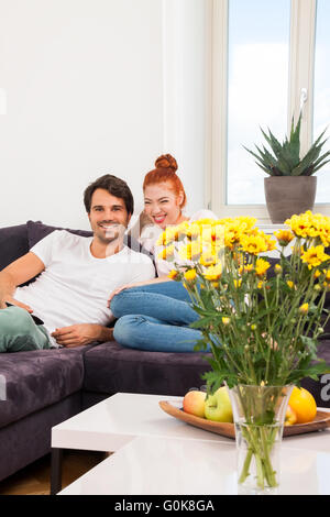 Glückliche Paar auf der Couch, Blick in Ferne Stockfoto