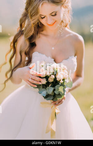 Wunderschöne blonde Braut Hochzeit Strauß rosa Rosen hautnah Stockfoto