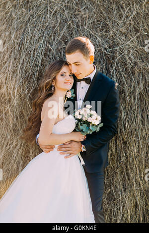 Close-up Portrait von glückliches junges Ehepaar umarmt auf Heuhaufen Stockfoto