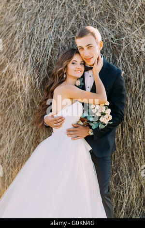 Close-up Portrait von glückliches junges Ehepaar umarmt auf Heuhaufen Stockfoto
