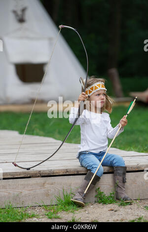 kleine lustige Mädchen spielen Indianer Stockfoto