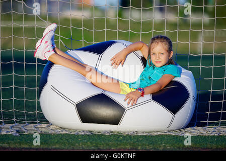 kleine lustige Mädchen auf Fußballstadion Stockfoto