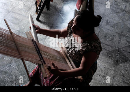 Eine Frau mit einem Backstrap Loom ein traditionelles weben Textilien und Designs in der Maya-Kultur in Antigua eine Stadt im zentralen Hochland von Guatemala Zentralamerika verwurzelt Stockfoto