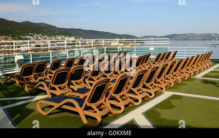 Leere Liegestühle auf dem oberen Deck eines Kreuzfahrtschiffes. Stockfoto