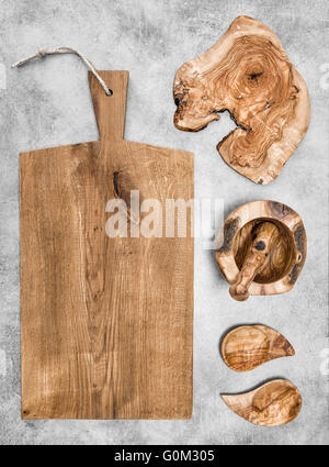 Schneidebrett und hölzerne Küchenutensilien auf Stein Hintergrund Stockfoto