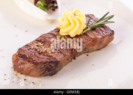 Gegrilltes Rindersteak, garniert mit Butter und Rosmarin Stockfoto