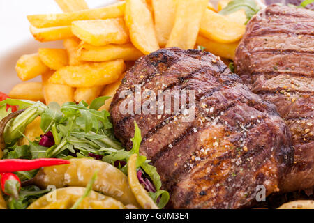 Platte mit gemischtem Fleisch, Salat und Pommes frites Stockfoto