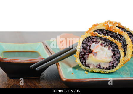 Gebackenes Sushi-Rollen auf Türkis Teller serviert Stockfoto