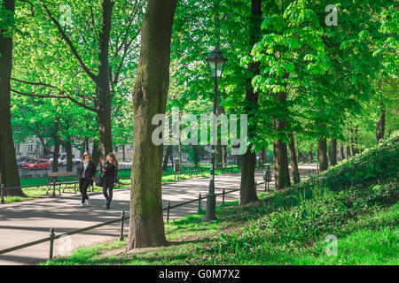 Krakauer Planty-Park, im Sommer zwei junge Frauen, die durch den Planty-Park im Zentrum von Krakow, Polen, spazieren. Stockfoto