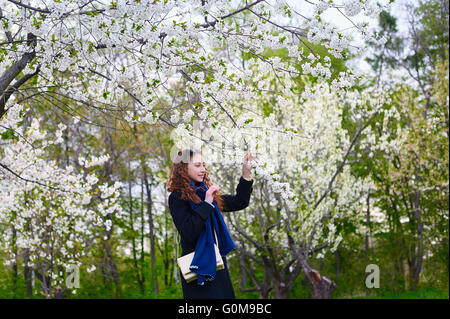 Portrait von junge schöne Frau im Frühjahr blühenden Bäumen Stockfoto