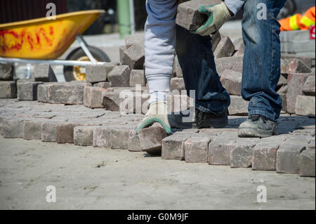 Ein Mann mit Ziegeln, Einbau einer Straße. Stockfoto