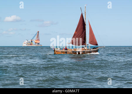 Kleine Segelyacht und große Ladung Schiff Überfahrt über die Nordsee in der Nähe von Hafen von Rotterdam, Niederlande Stockfoto