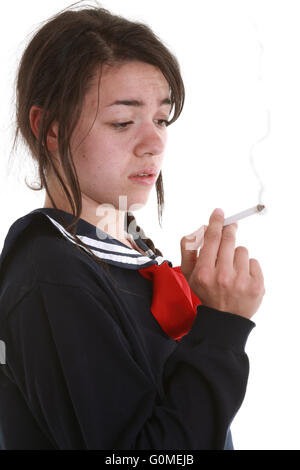 Gemischte Rassen junge Frau wie ein Schulmädchen in japanischem Stil Uniform raucht eine Zigarette. Stockfoto