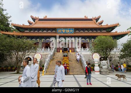 Mönche und Touristen vor der Main Schrein Hall des Buddha im Po Lin Monastery auf Lantau Island in Hongkong, China. Stockfoto