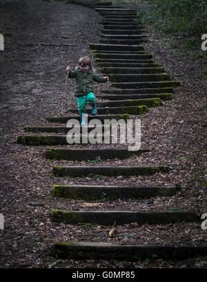 Ein kleiner Junge, die hölzernen Treppenstufen in Wäldern, Worcestershire, UK Stockfoto