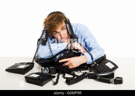 Erschöpften Mann sitzt mit einem Bündel von Handys über ihn Stockfoto