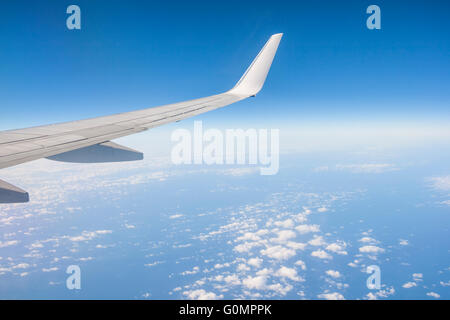 Blick vom th Fenster eines Flugzeugs des Flügels am Himmelshintergrund Stockfoto