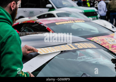 DUBLIN, IRLAND. 1. Mai 2016 - gilt ein Mann Vinyl Sticker für ein Auto zu Beginn des Rennens Gumball 3000 nach Budapest. Stockfoto