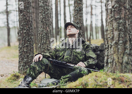 Soldat oder Jäger mit Gewehr im Wald schlafen Stockfoto